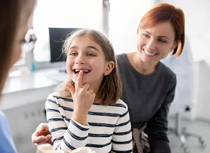 Child showing missing tooth to the dentist