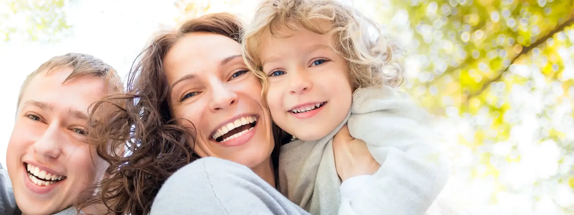 Smiling family outside in the sunshine